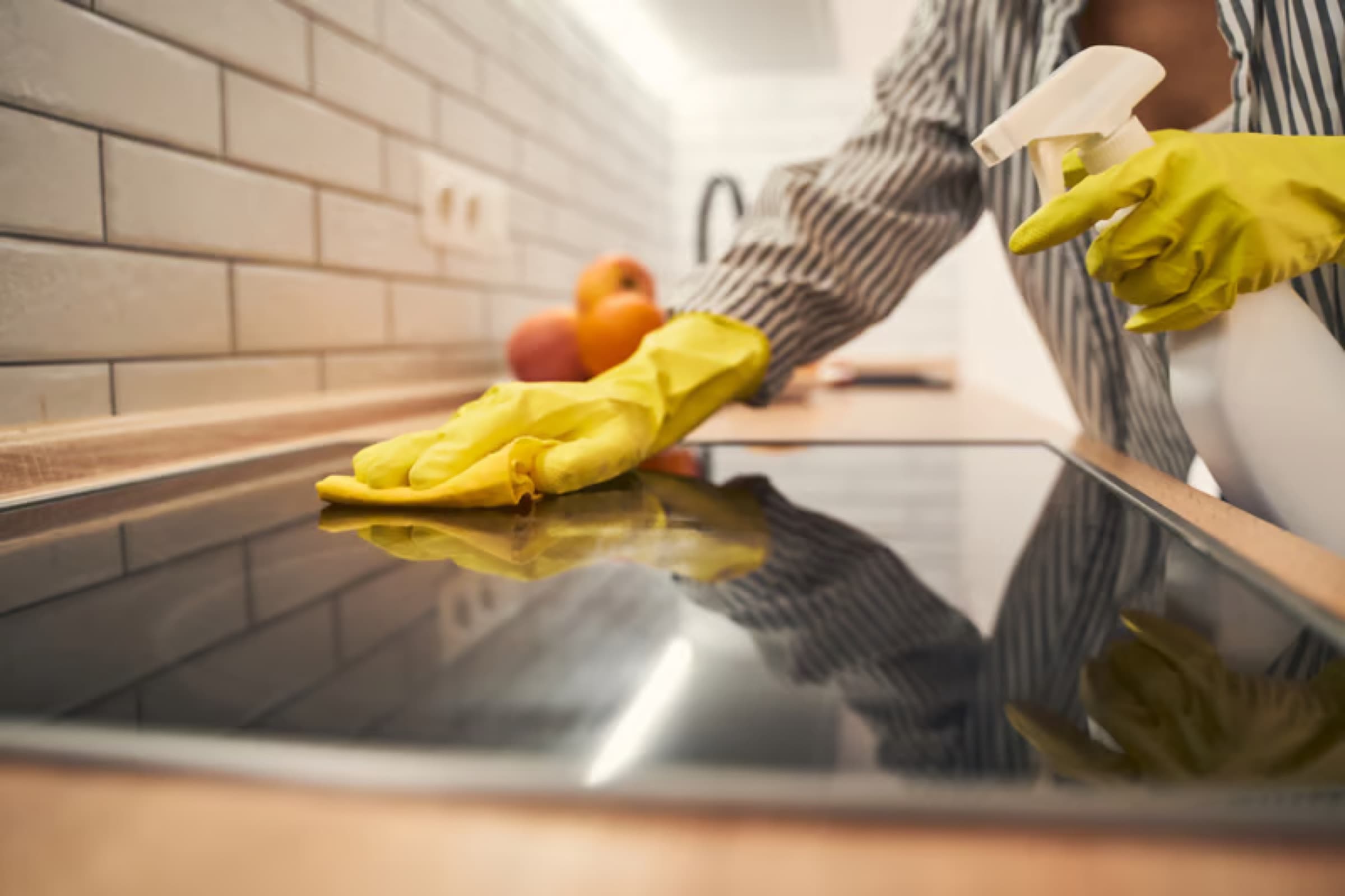 Gloved hand detailing a kitchen cooktop